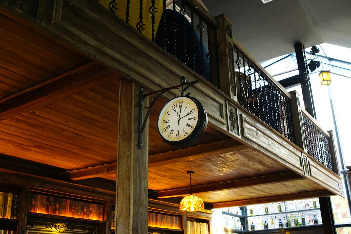 Vintage large clock wall decor mounted securely on a living room accent wall with visible molding and warm lighting